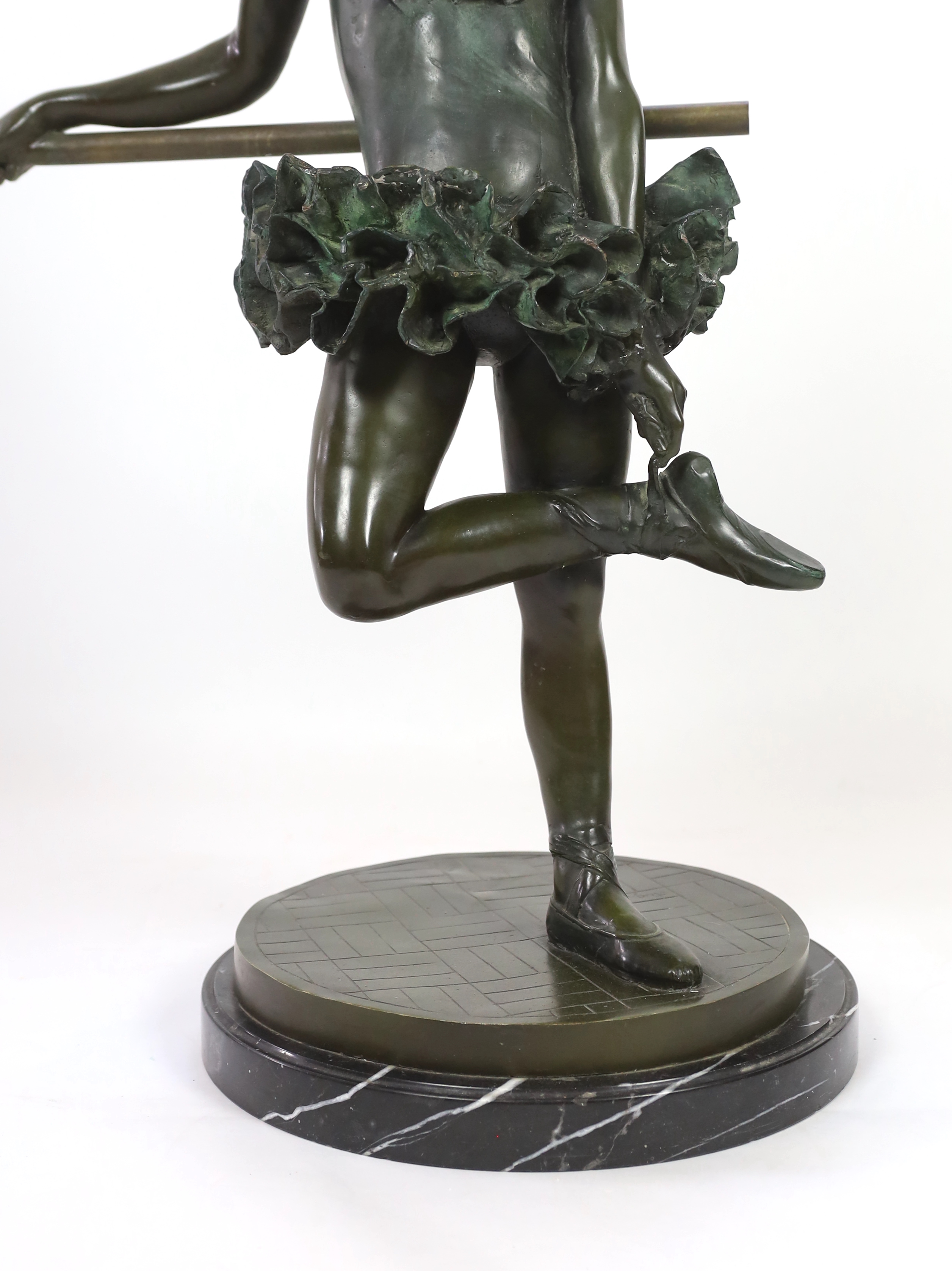 After Auguste Moreau (French, 1834-1917). A bronze figure of a ballerina, standing leaning against a rail, bears signature in the bronze, on marble plinth, height 110cm diameter 47cm.